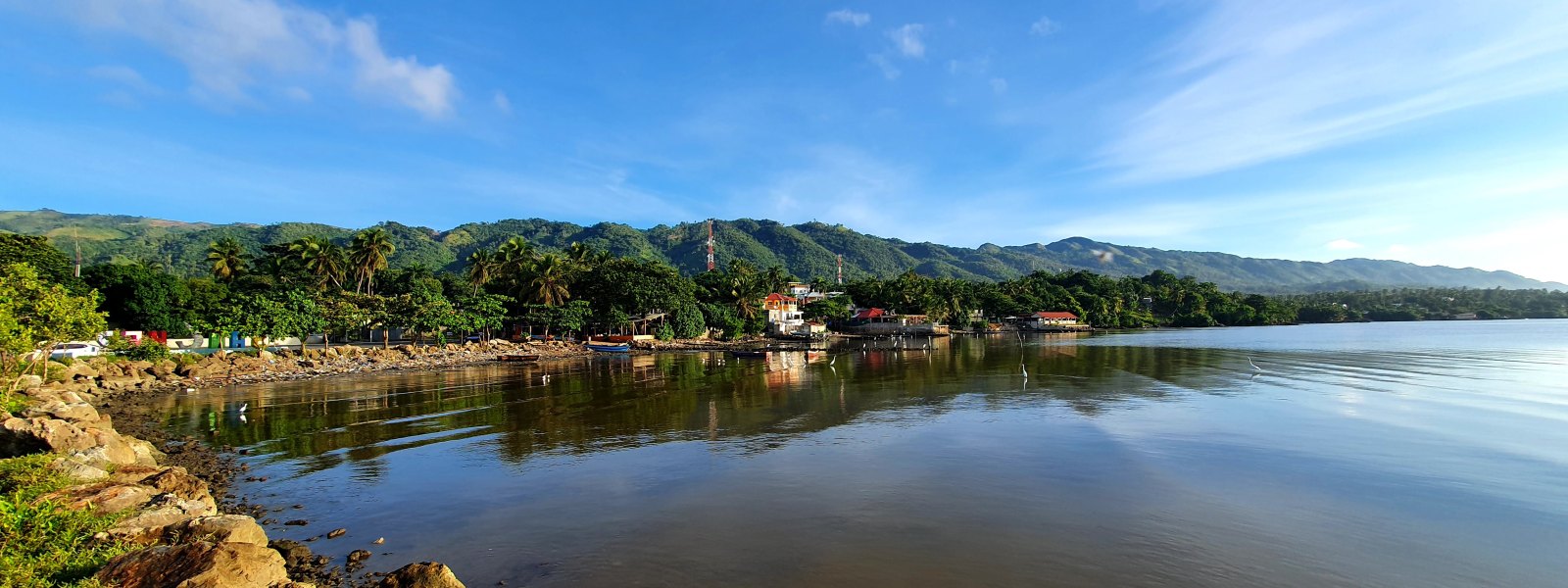 Costa de Sánchez con viviendas, montañas y agua de la bahía